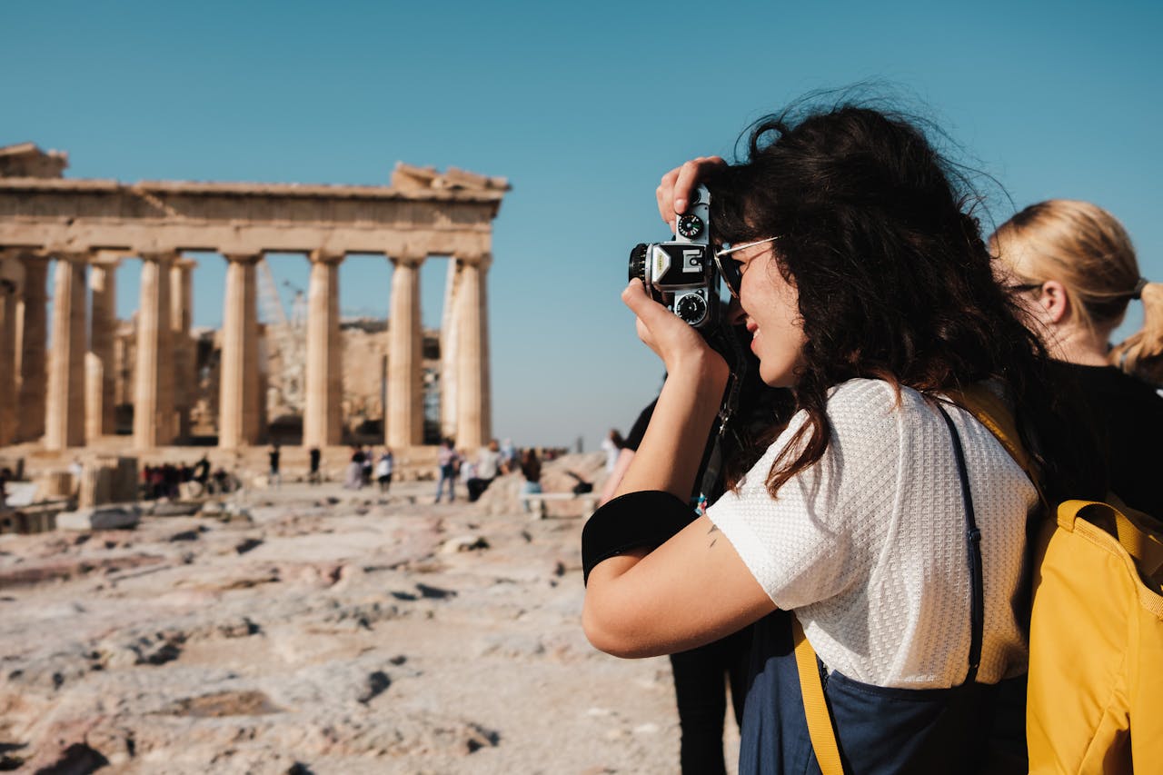 woman shooting photograph at ancient ruins